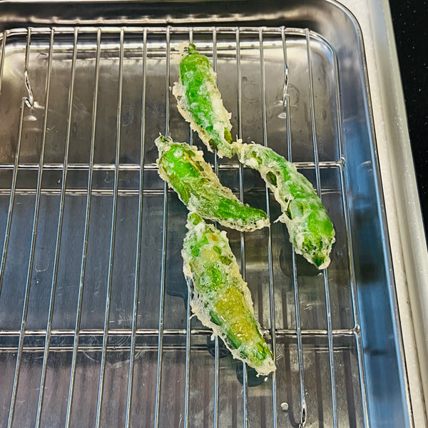 adding tempura onto a draining rack and deep frying the rest of the ingredients in batches