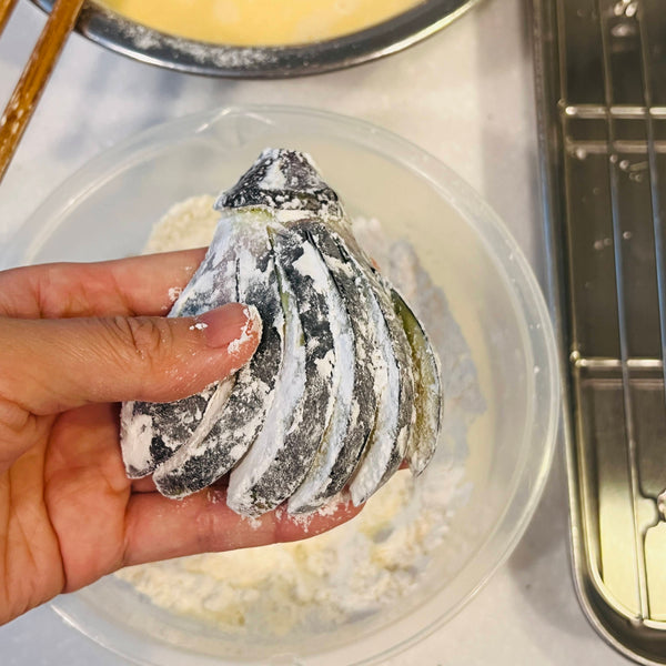 coating the fanned eggplant in flour, making sure to cover every crevice