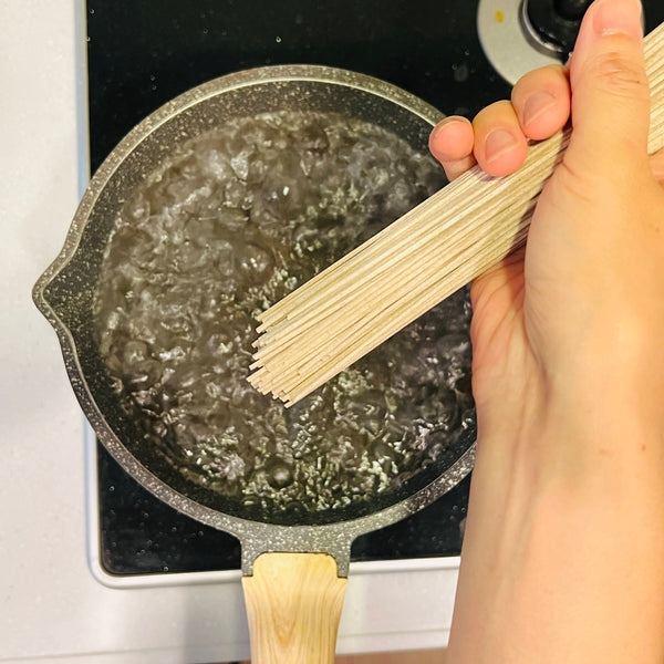 adding the soba noodles to boiling water