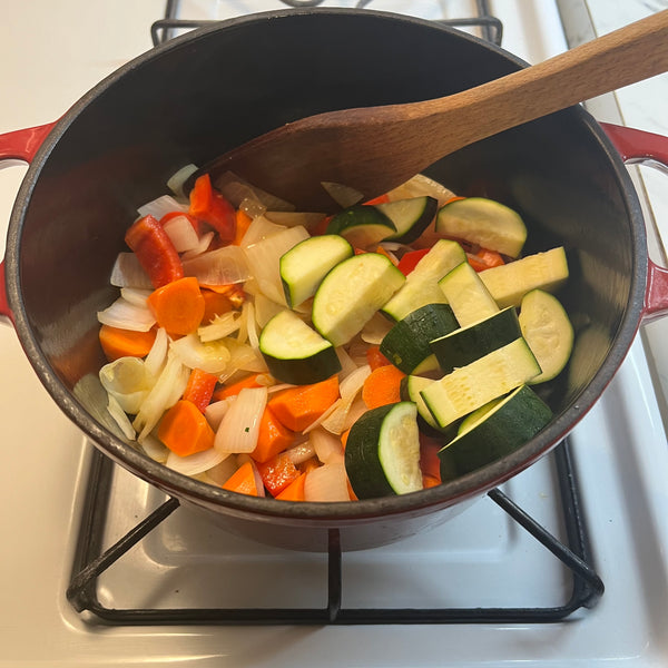 adding the rest of the veggies into the pot and sauteing