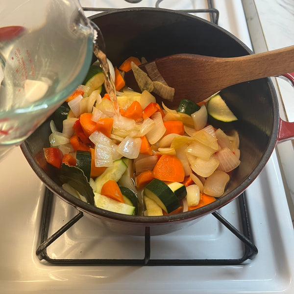 adding water to the sautéed veggies