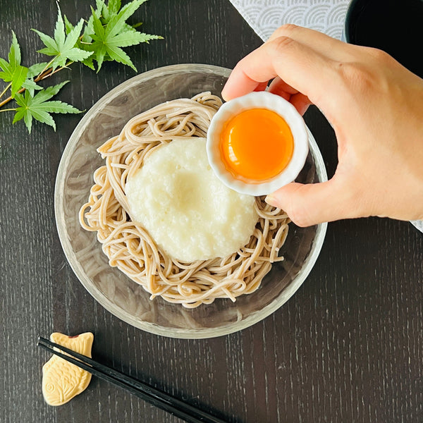 adding an egg yolk to tororo soba