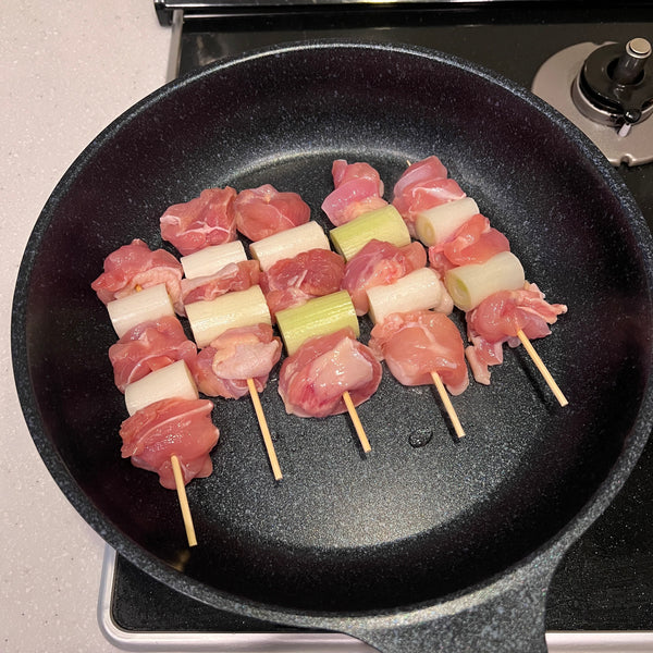placing yakitori into the pan
