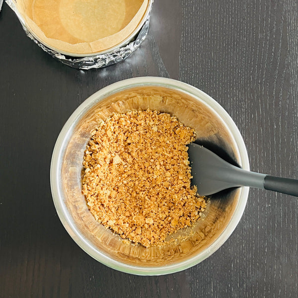 mixing the biscuits and melted butter until it achieves a wet sand texture