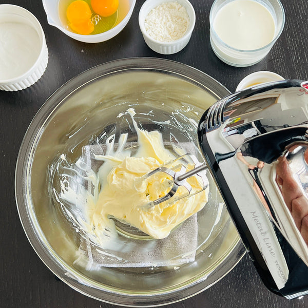 mixing the cream cheese with a hand mixer