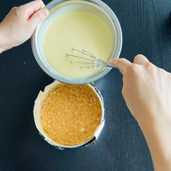 pouring the smooth yuzu cheesecake batter into the cake pan