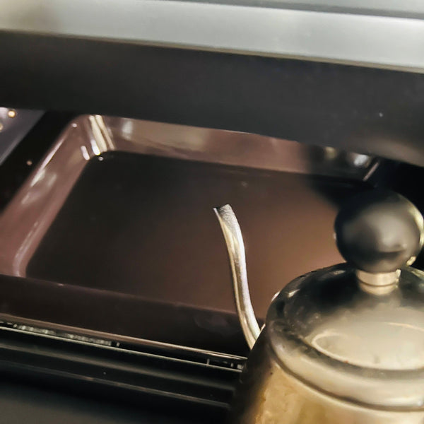 pouring hot water into the baking dish