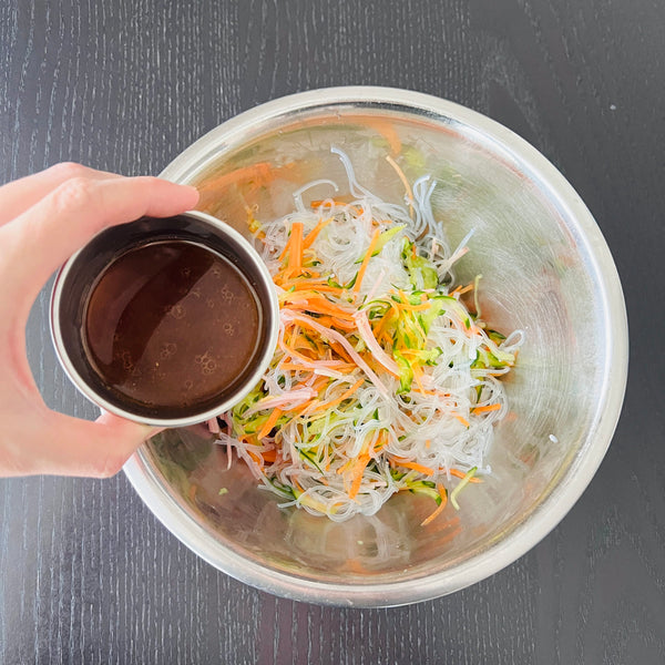 adding the glass noodles, ham, and dressing to the salad