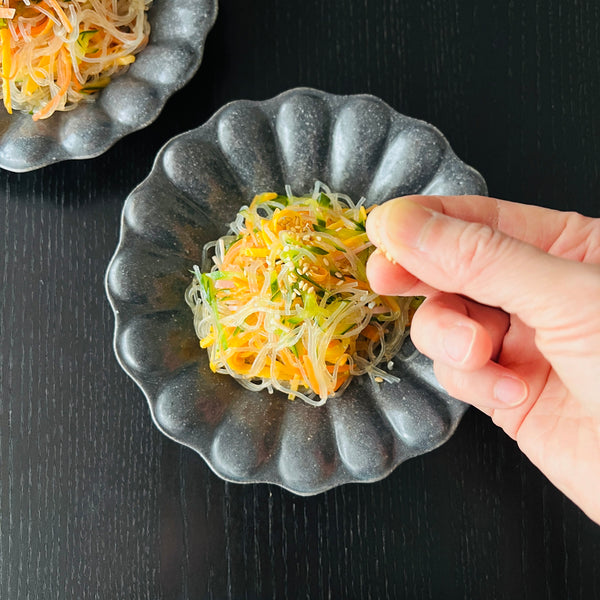 garnishing harusame salad with sesame seeds