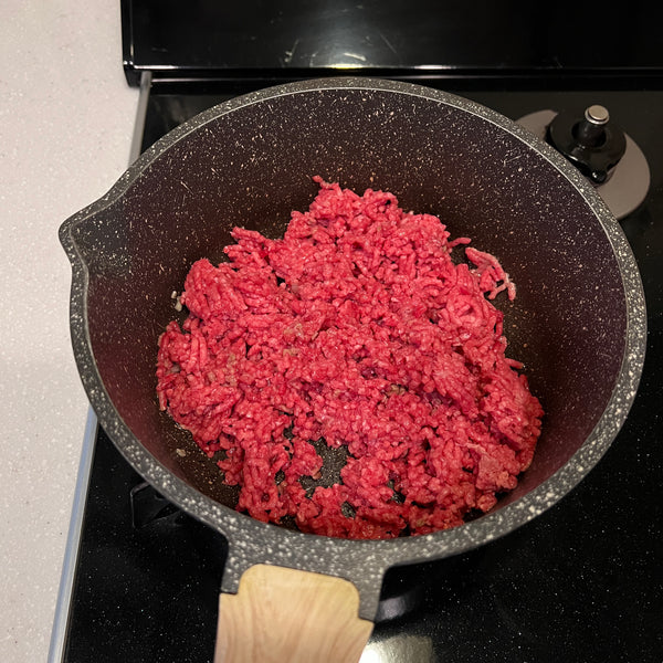 adding ground beef to the frying pan