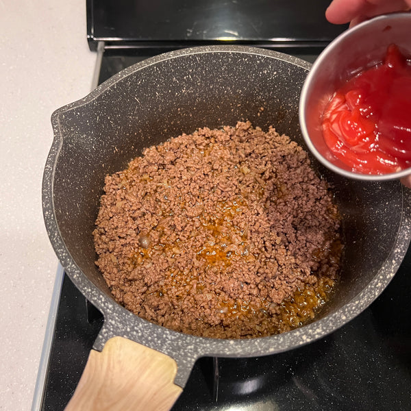adding ketchup to the taco meat