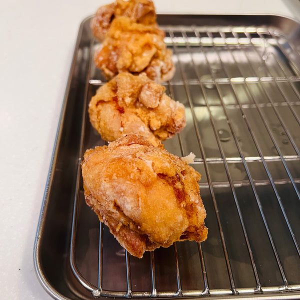 putting the fried karaage onto a rack to cool off