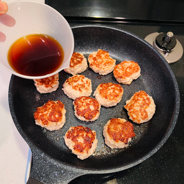 adding the soy seasonings to the tsukune