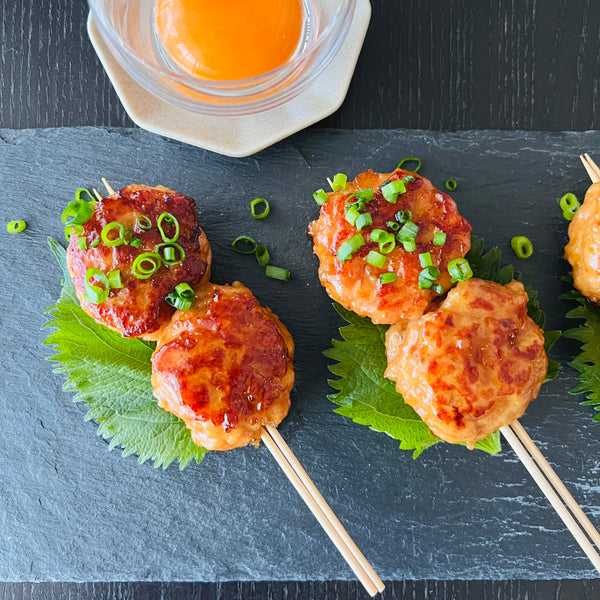 garnishing tsukune with chopped green onions and shiso
